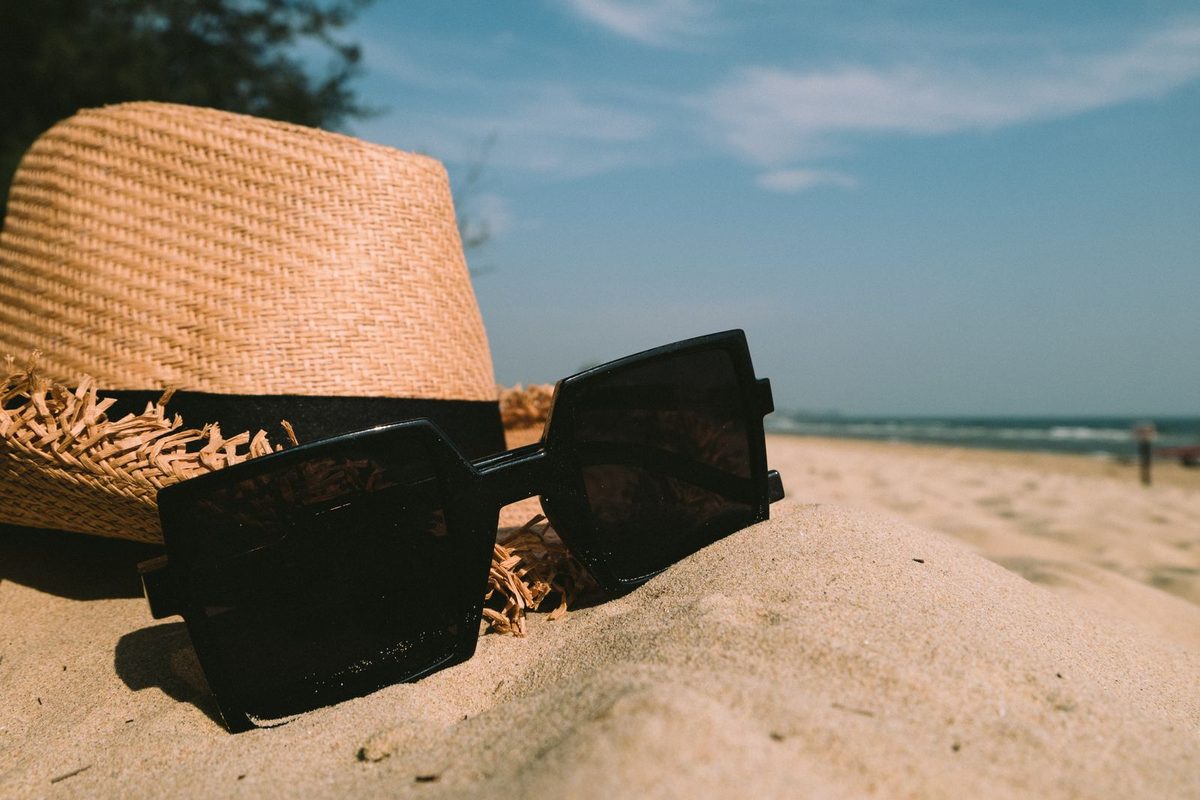 A black square frame and a straw hat on a beach